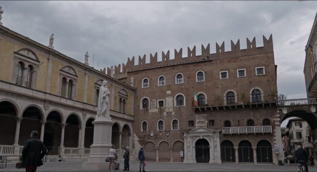 Federica Pellegrini - Underwater (2022) movie still: wide — A historic Italian square features medieval brick architecture with crenellated…
