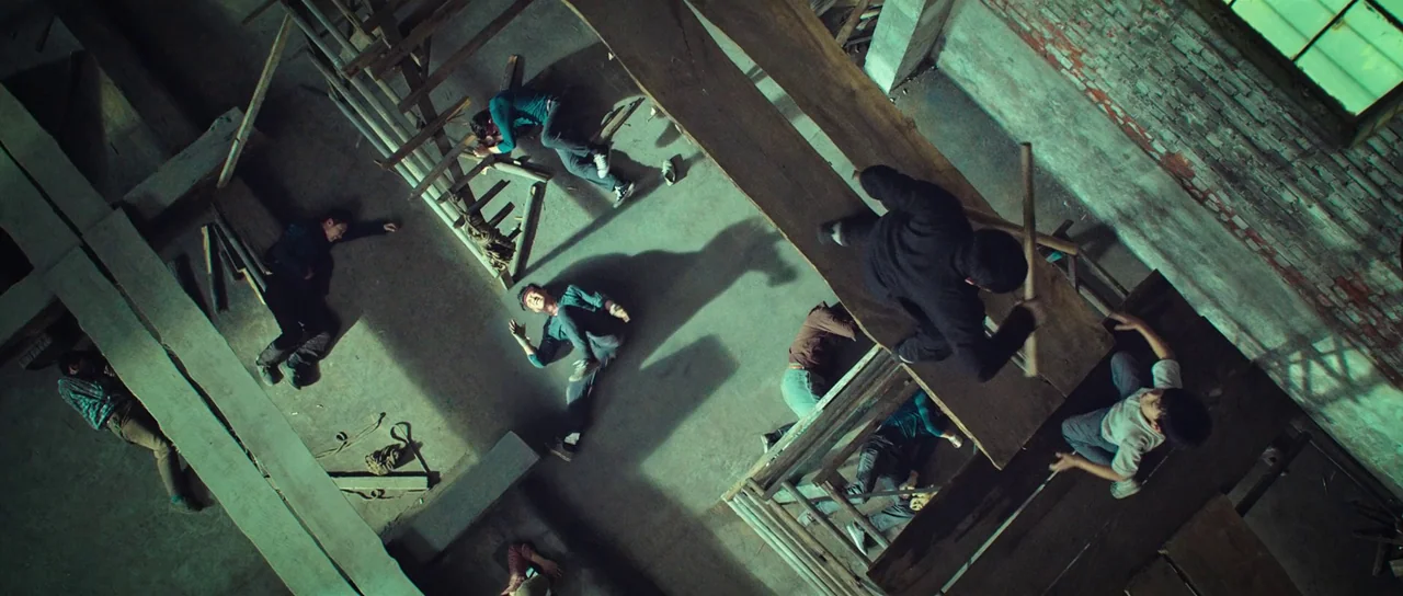 Ip Man 3 (2015) movie still: wide — A construction site interior features unfinished brick walls and wooden scaffolding planks underfoot. A man in…