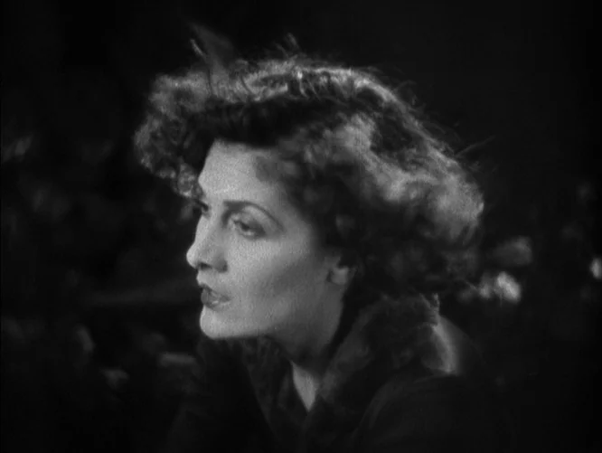 The Last Command (1928) movie still: closeup — A dark outdoor setting at night with a woman captured in close-up profile. The background is…