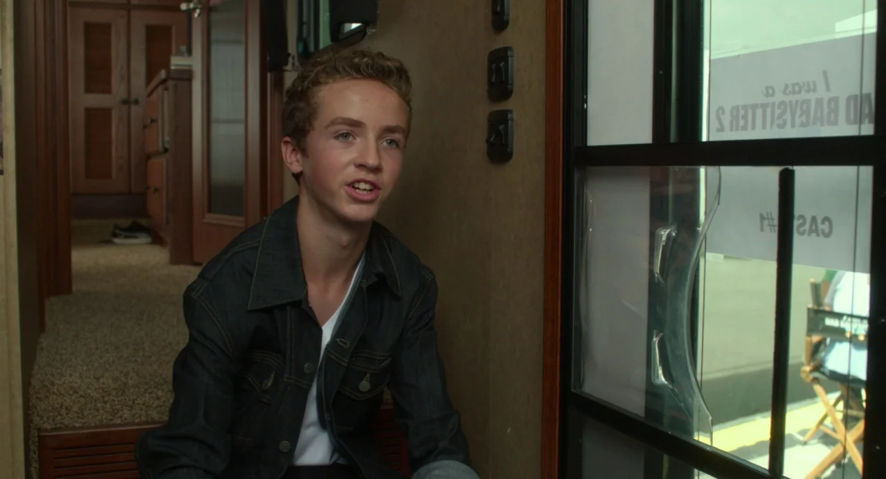 Maps to the Stars (2014) movie still: medium — The interior of a motorhome features a narrow corridor with wooden cabinetry and trim. A young…