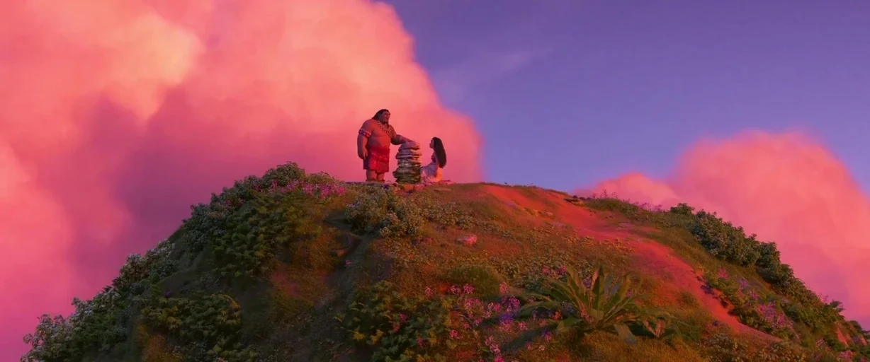 Moana (2016) movie still: wide — A grassy hill with wildflowers and ferns stands beneath a vast pink sunset sky. A large man and a young girl stand…