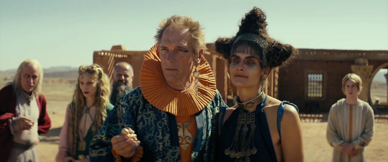 Seneca: On The Creation Of Earthquakes (2023) movie still: medium — An arid desert environment features weathered mud-brick ruins under a clear…