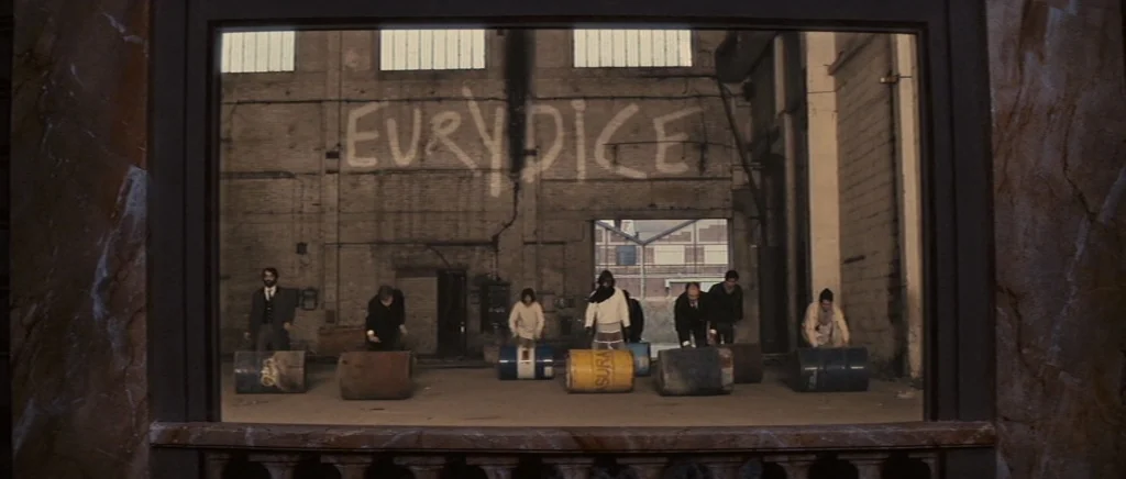 You Ain’t Seen Nothin’ Yet (2012) movie still: wide — A wide industrial space has a wall with the word EURYDICE spray-painted on it. Seven people…