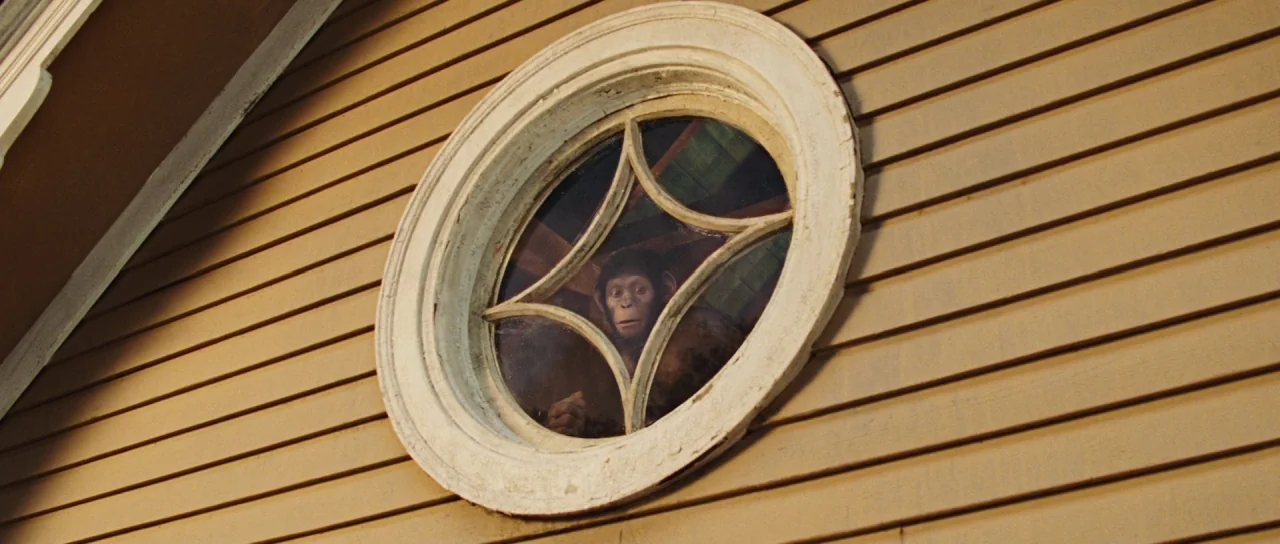 Rise of the Planet of the Apes (2011) movie still: medium — Tan horizontal wooden siding covers the exterior wall of a building. A circular window…