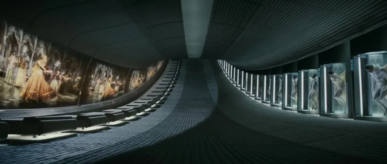 Mr. Nobody (2009) movie still: wide — A futuristic corridor features a row of glass pods containing suspended human forms. To the left, a large…