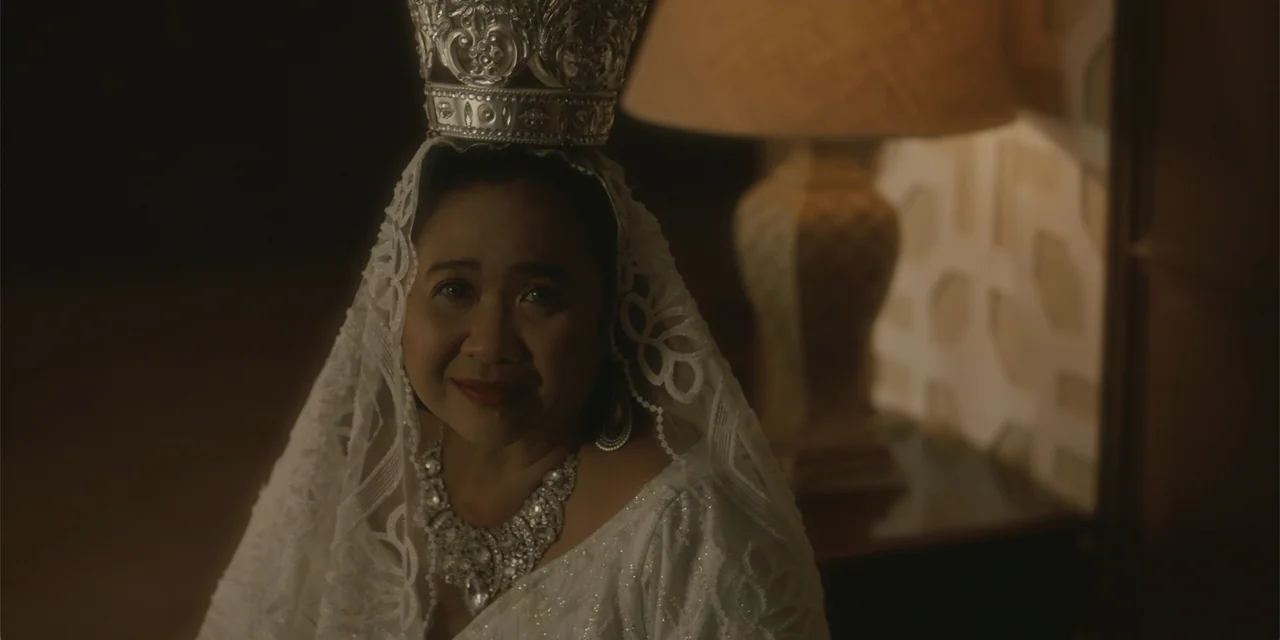 Ten Little Mistresses (2023) movie still: closeup — A dimly lit room features a woman wearing a decorative silver crown and veil. The woman looks…