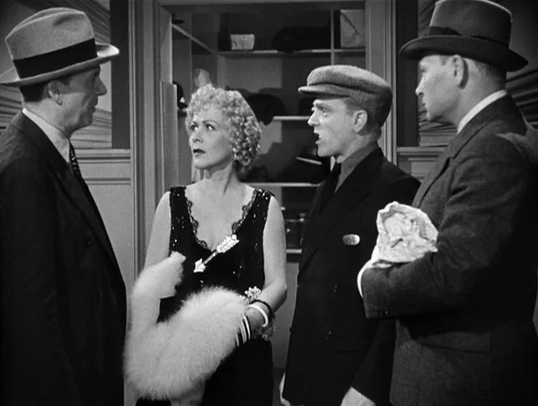 The Roaring Twenties (1939) movie still: medium — Four people stand in a hallway near an open storage closet with shelves. They are gathered in a…