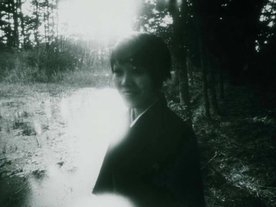 Throw Away Your Books, Rally in the Streets (1971) movie still: medium — A dark, wooded area borders a wet, muddy ground patch under strong light. A…
