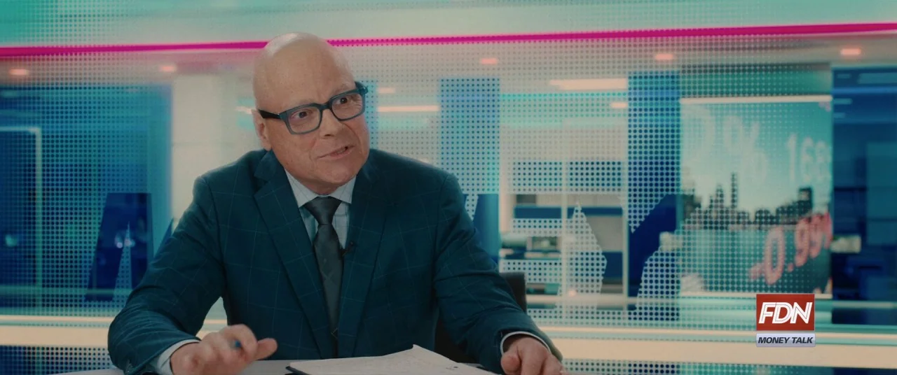 I Care A Lot (2020) movie still: medium — A high-tech news broadcast set featuring backlit LED display walls showing stock market data. A…
