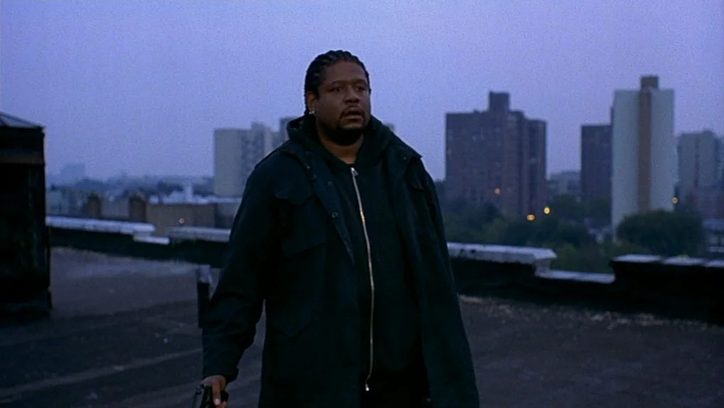 Ghost Dog: The Way of the Samurai (1999) movie still: medium — A rooftop terrace overlooks a city landscape of high-rise apartment buildings at…