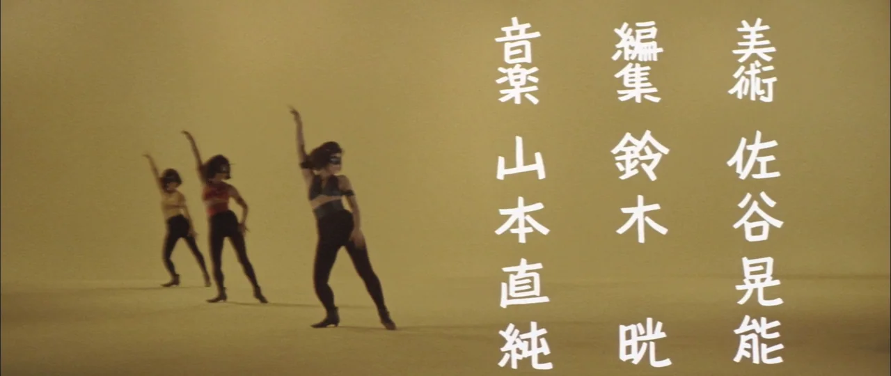 Black Tight Killers (1966) movie still: wide — A spacious studio with a solid mustard-yellow background and floor. Three dancers perform…