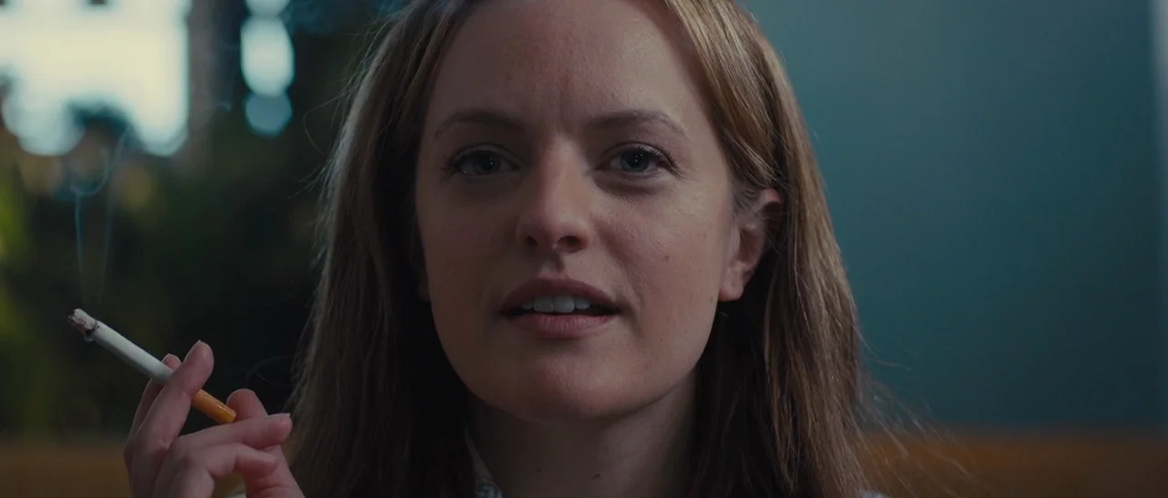 High-Rise (2015) movie still: closeup — A close-up shot of a woman sitting in a booth. She holds a lit cigarette between her fingers while facing…