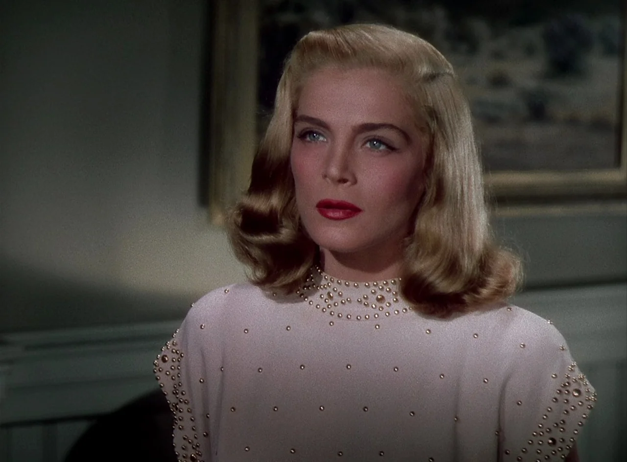 Desert Fury (1947) movie still: medium — A well-lit room features a framed painting visible on the wall behind the subject. A woman with styled…