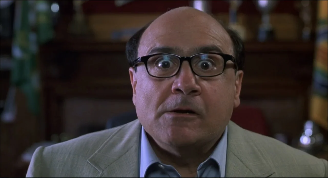 What's the Worst That Could Happen? (2001) movie still: closeup — A man stands in an office with dark wood paneling and shelves behind him. The man…