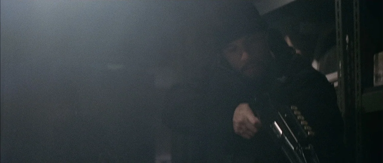 A Man Apart (2003) movie still: medium — A dark, smoke-filled room contains metal shelves partially obscured by heavy shadows. A man in a dark…