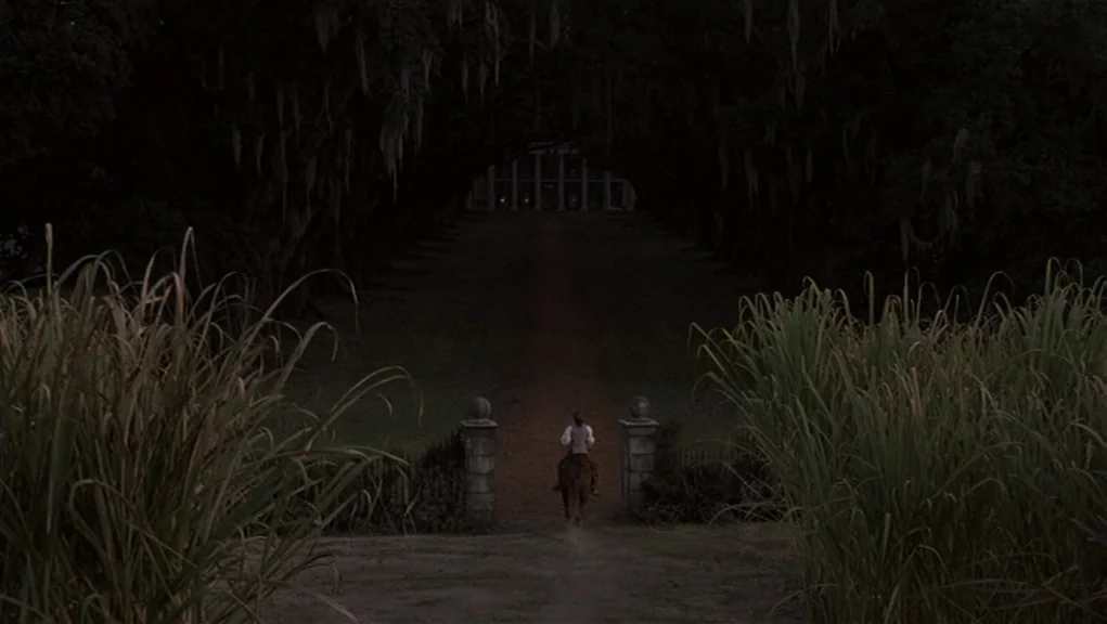 Interview With The Vampire movie still: wide — A long dirt path lined by large oaks with hanging Spanish moss leads home. A lone rider on horseback…
