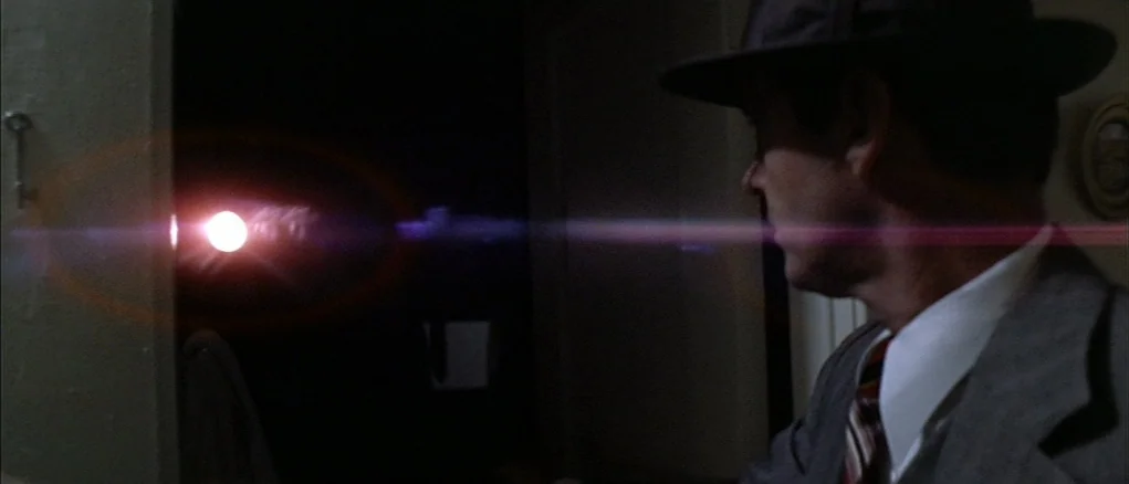 Chinatown (1974) movie still: medium — A dimly lit narrow corridor features a single bright light source at the end. A man in a fedora and suit…