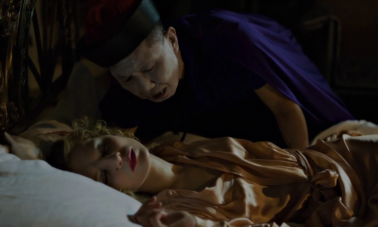 Bloodsuckers (2021) movie still: medium — A dark bedroom features a woman sleeping soundly under ornate dark wooden bed frames. An East Asian man…