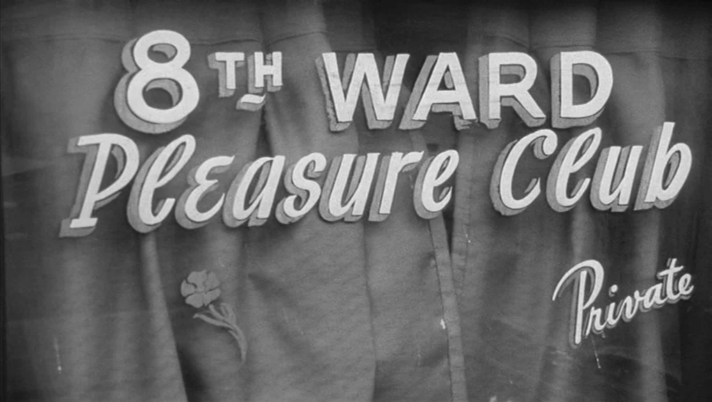 Who’s That Knocking At My Door (1967) movie still: closeup — A glass storefront window displays bold white lettering advertising the 8th Ward…