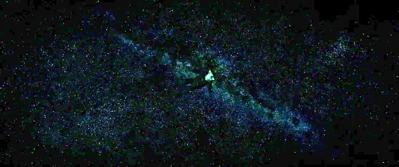 Gravity (2013) movie still: wide — A vast, dark expanse filled with scattered white points representing a star field. A lone figure in a dark suit…
