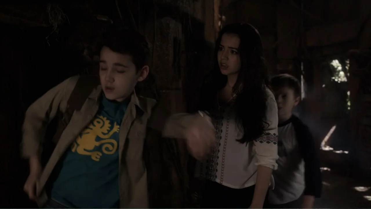 Legends of the Hidden Temple (2016) movie still: medium — A dimly lit room with stone walls and wooden architectural elements in the background.…
