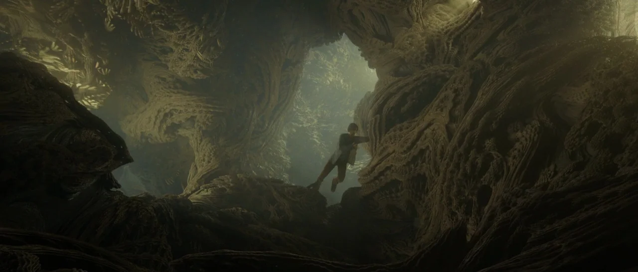 Doctor Strange (2016) movie still: wide — A subterranean cavern features fractal-like organic stone walls and a diffuse light source. A lone man…