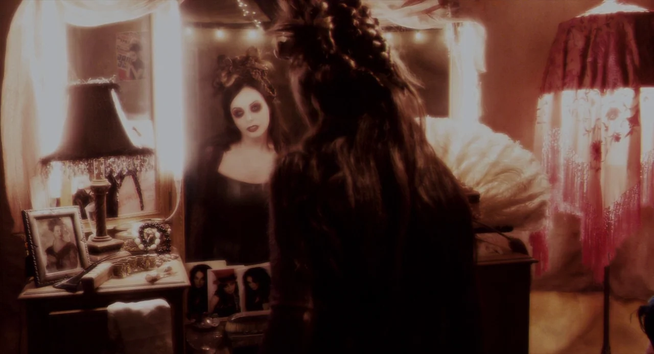 Repo! The Genetic Opera (2008) movie still: medium — A dimly lit room contains a cluttered vanity table with personal items and photographs. A woman…