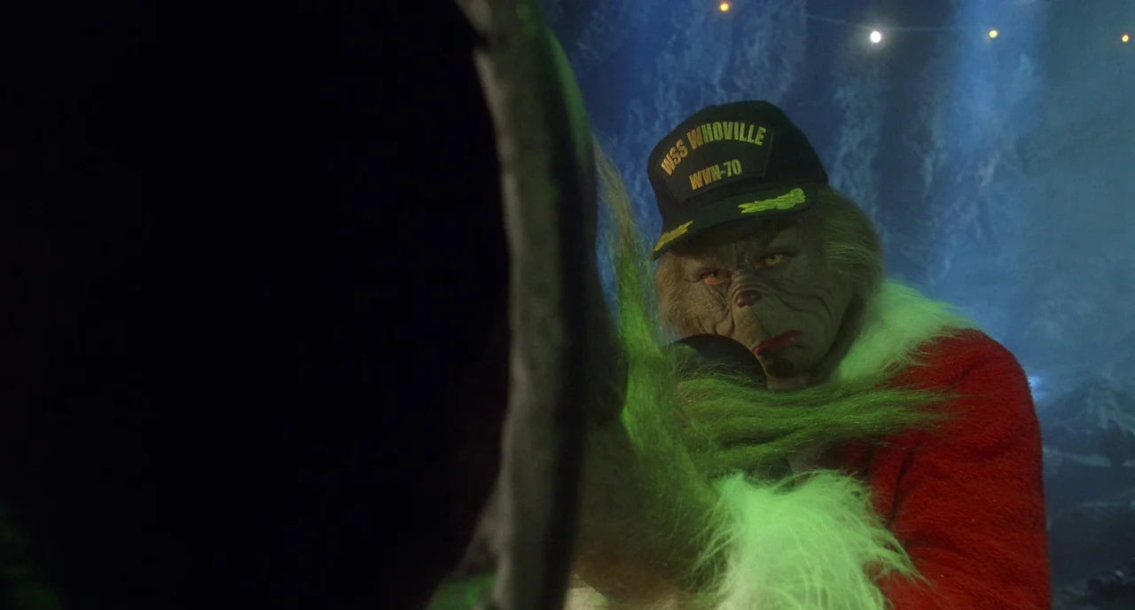 How The Grinch Stole Christmas (2000) movie still: medium — A dark, dimly lit cave interior with rock textures visible in the background. The Grinch…