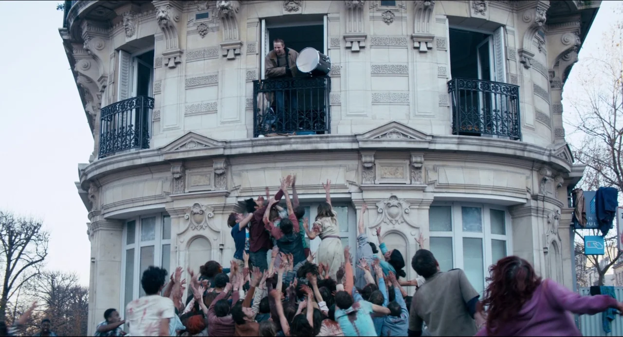 The Night Eats the World (2018) movie still: wide — A stone Haussmann-style building features a prominent balcony and tall decorative arched…