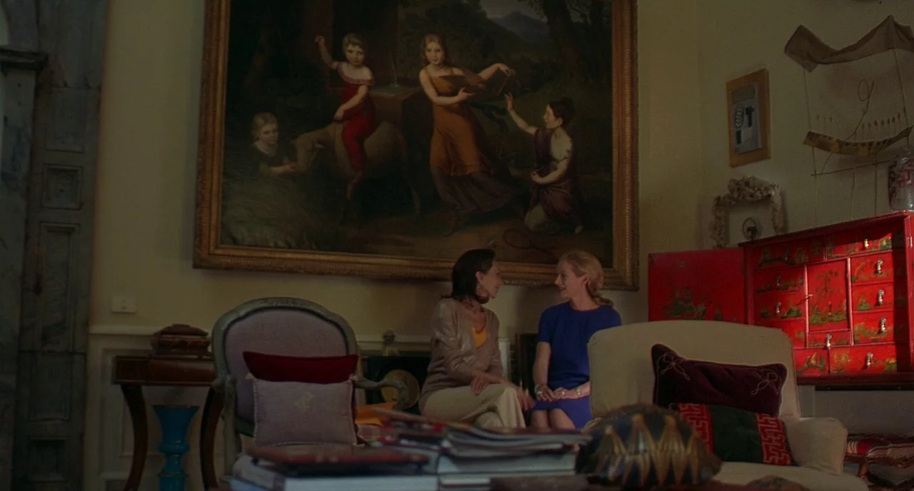 Making of: I Am Love (2009) movie still: wide — An upscale living room features a large oil painting above two women sitting together. The space is…