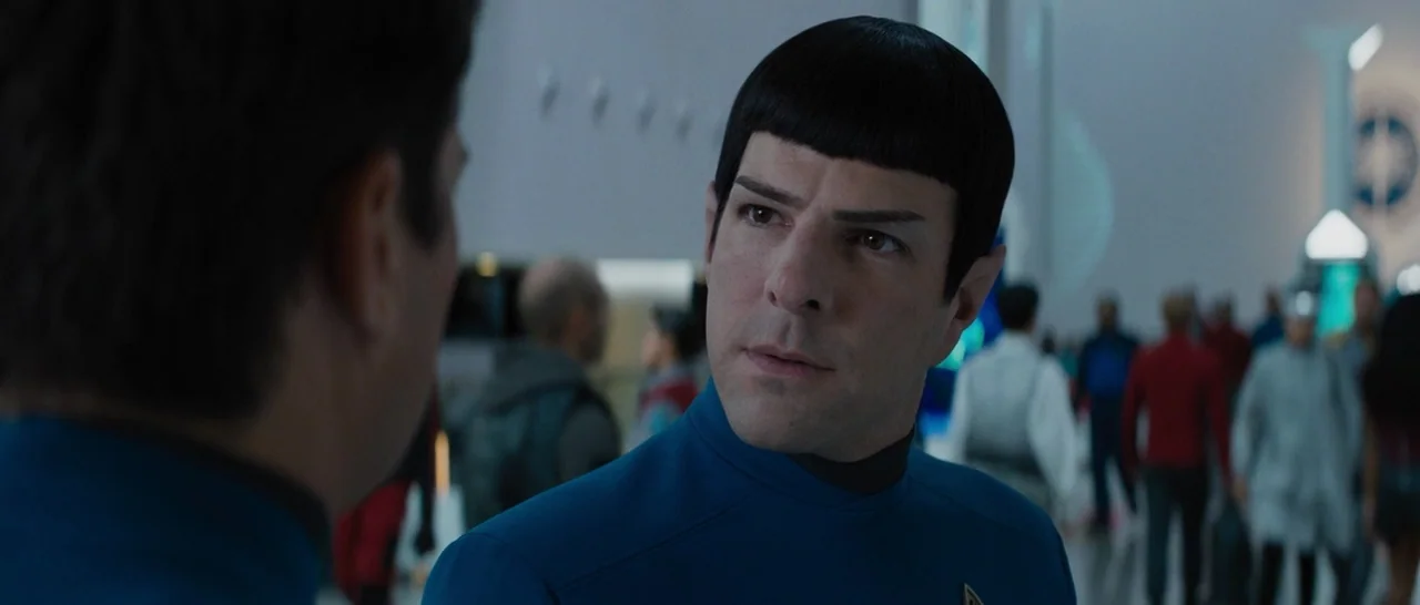 Star Trek Beyond (2016) movie still: closeup — A bustling interior corridor of a futuristic vessel features clean white surfaces and many people. A…