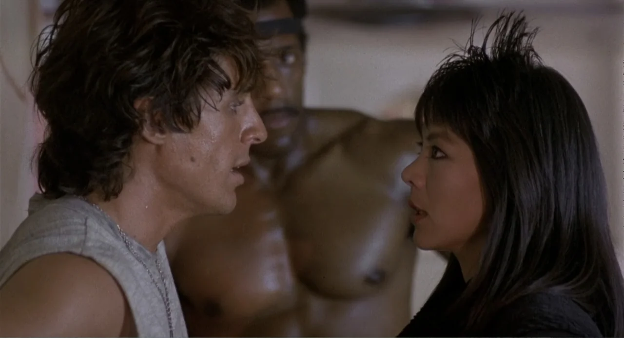 American Ninja 3: Blood Hunt (1989) movie still: medium — An interior space with light-colored walls and three individuals standing near one…