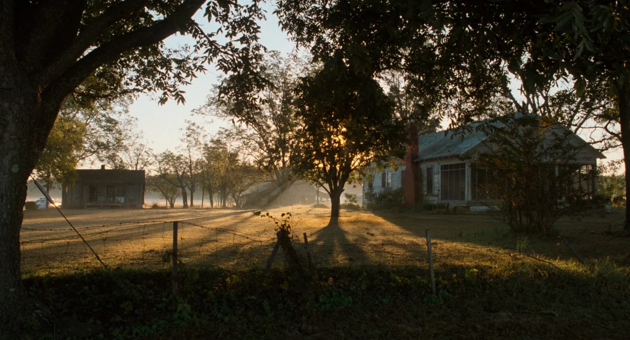 One False Move (1991) movie still: establishing — A rural homestead features an aging farmhouse with a chimney in the morning light. Wisps of mist…