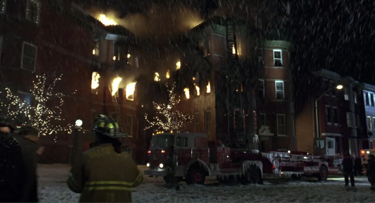 Ladder 49 (2004) movie still: wide — An urban block at night experiences a structural fire during a heavy snowstorm. A firefighter in protective…