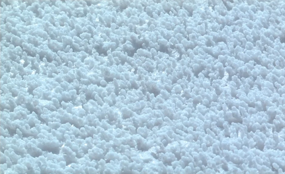Beau Travail (1999) movie still: establishing — A vast salt flat covered in dense, uneven salt crystal formations under bright light. The surface is…