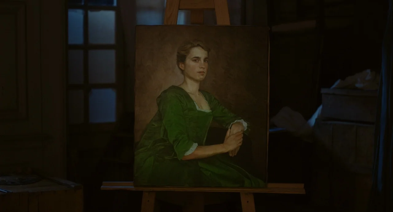 Portrait of a Lady on Fire movie still: medium — A portrait of a woman in a green dress rests on a wooden easel. The room is dimly lit, with a…