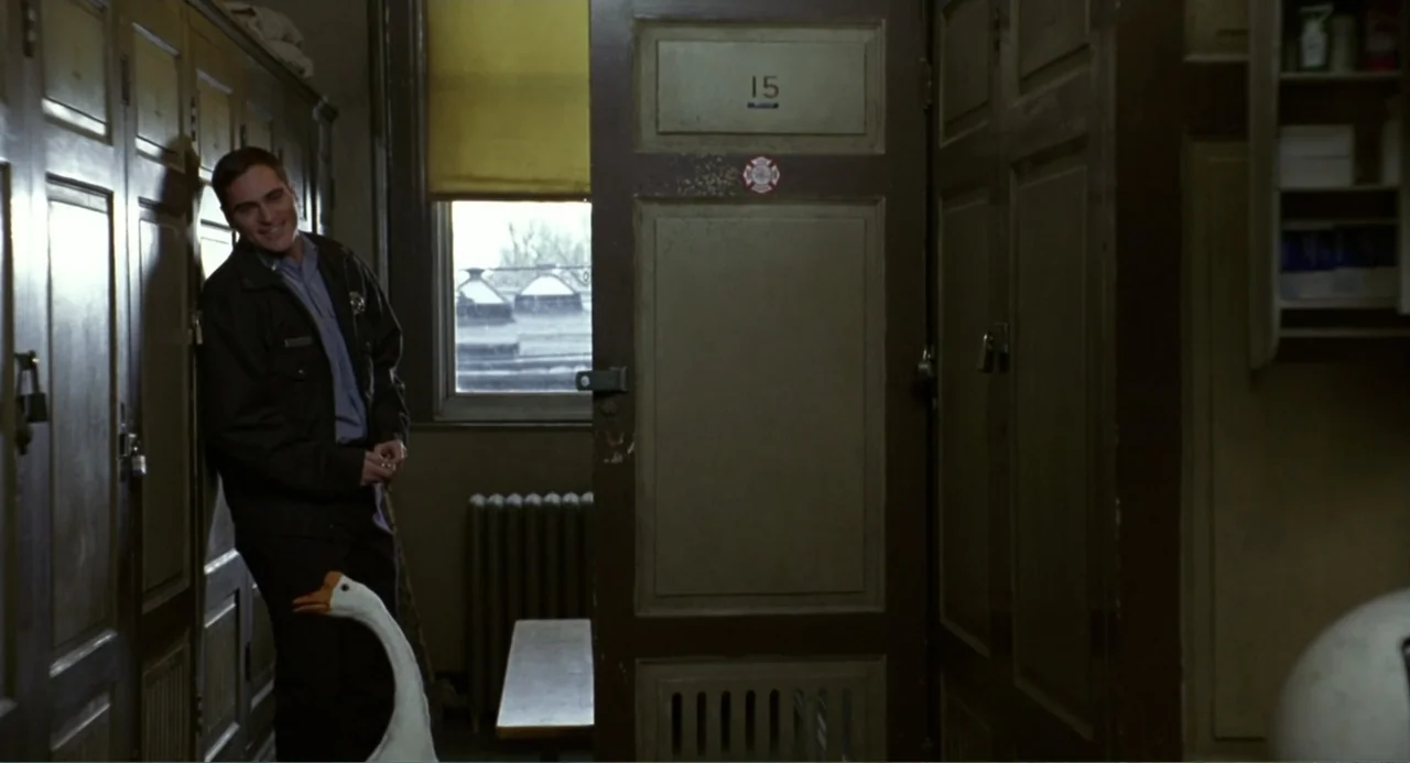 Ladder 49 (2004) movie still: medium — A locker room features rows of tall, dark wooden lockers and a central bench. A man in a work uniform leans…