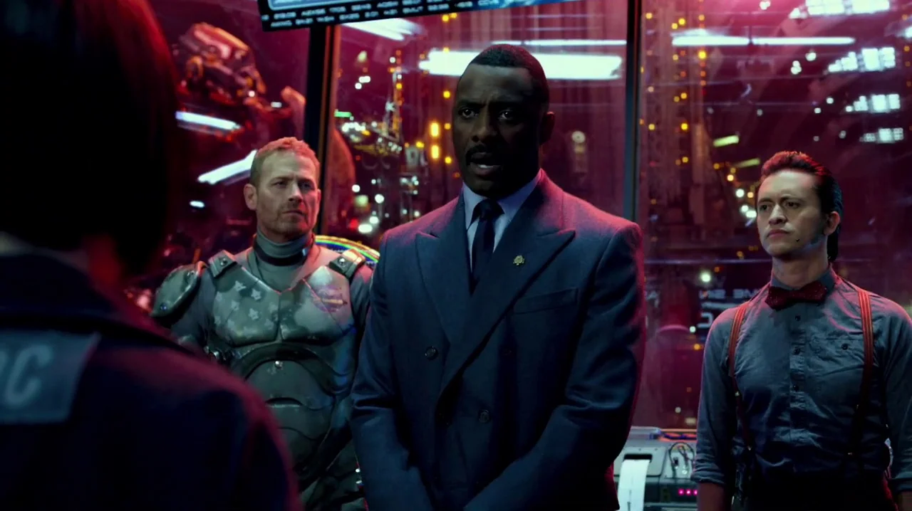 Pacific Rim (2013) movie still: medium — A dark, futuristic command center filled with glowing digital displays and technical equipment. Three men…