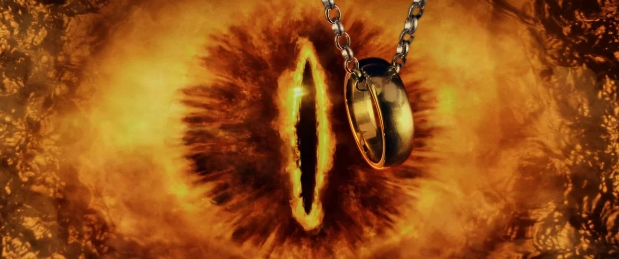 The Lord of the Rings: The Fellowship of the Ring (2001) movie still: closeup — A golden ring hangs by a metal chain in front of a giant glowing…