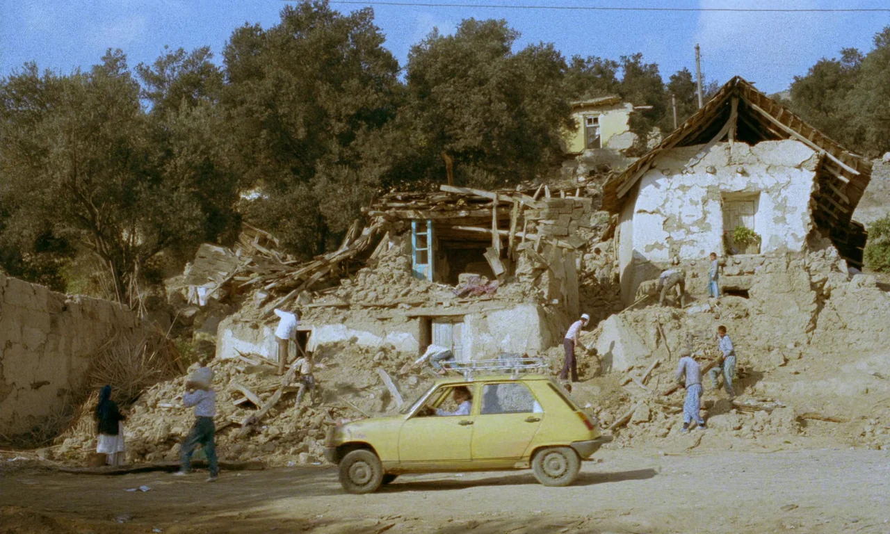 Life, and Nothing More (1992) movie still: wide — A rural hillside area features severely damaged mud-brick houses with collapsing timber roofs.…