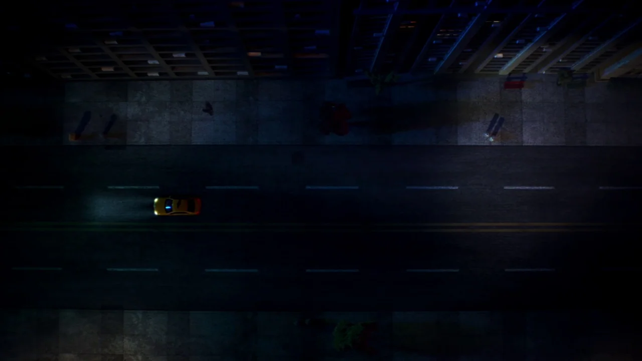 Piercing (2018) movie still: establishing — A top-down view shows an urban street flanked by dark multi-story commercial buildings at night. A…