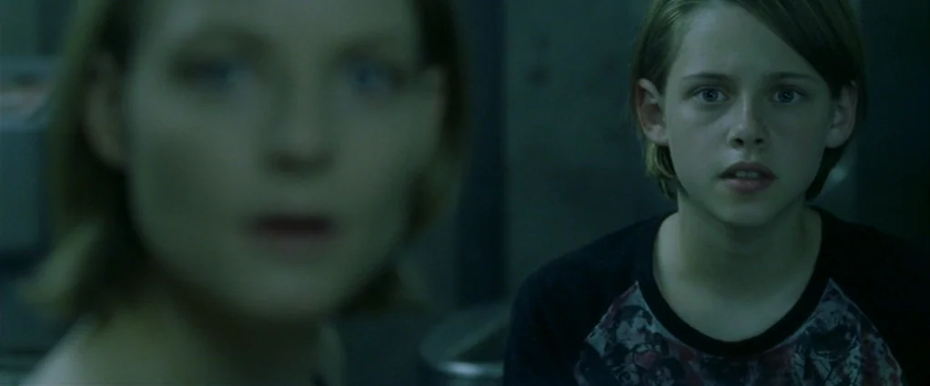 Panic Room (2002) movie still: medium — A dark, dimly lit interior space with muted colors and indistinct surroundings. A young woman and an older…