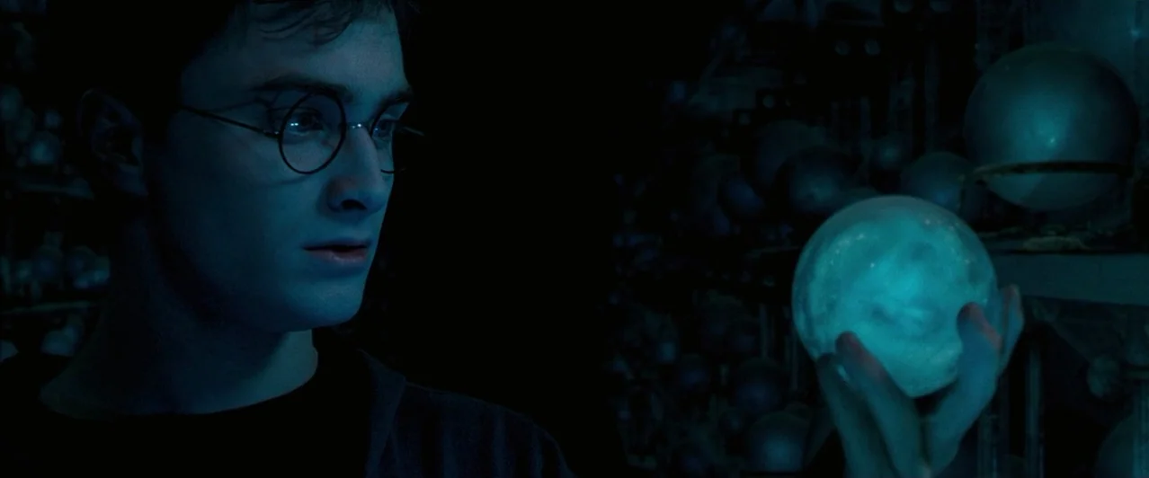 Harry Potter & The Order of the Phoenix (2007) movie still: medium — A dark space filled with rows of rounded glass spheres on shelves. A young man…