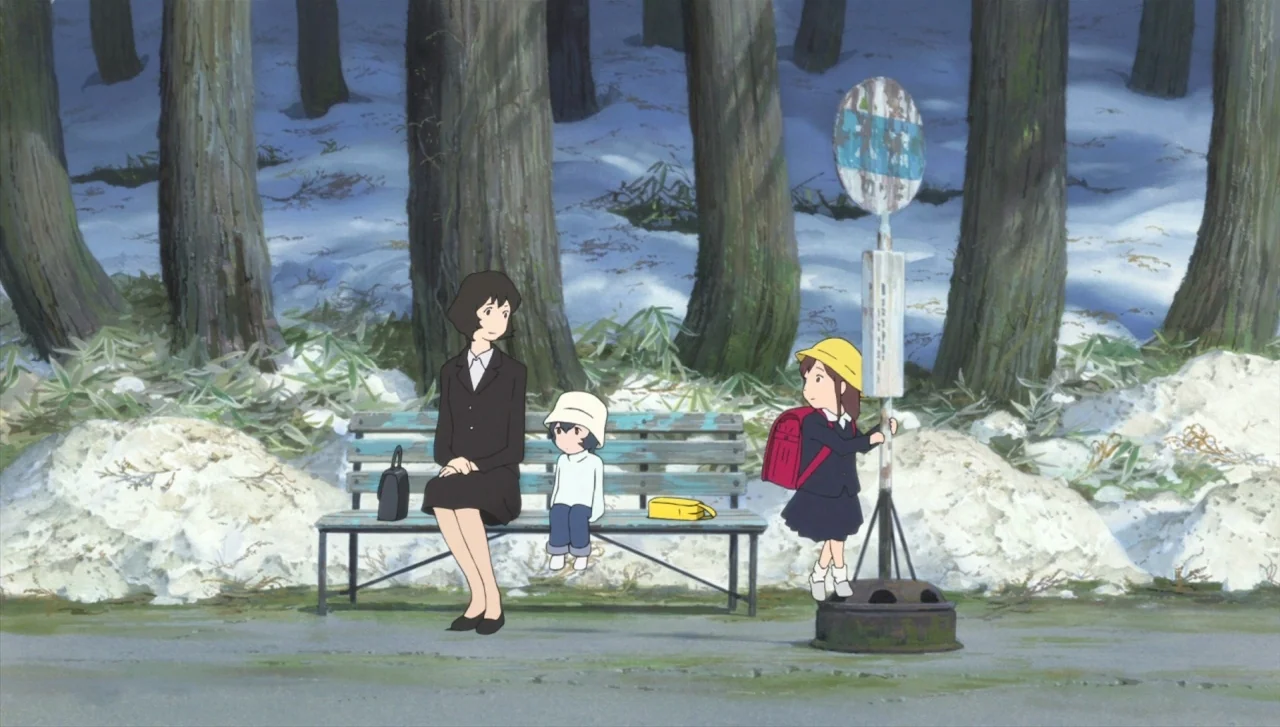 Wolf Children (2012) movie still: fullbody — A bus stop bench sits in front of a snow-dusted forest of tall trees. A woman and two children wait…