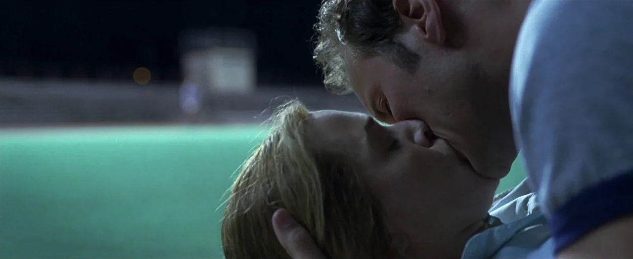Little Children (2006) movie still: closeup — A night view at a sports complex with artificial turf illuminated by stadium lights. A young man and…