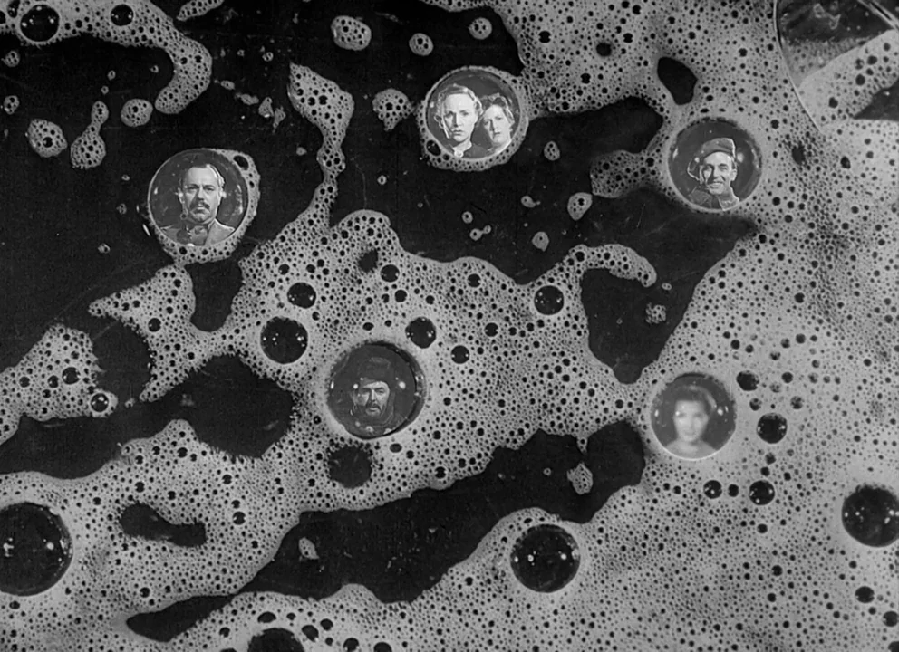 Odd Man Out (1947) movie still: closeup — Dark liquid with a layer of white soap bubbles covers the entire frame. Six distinct circular photographic…