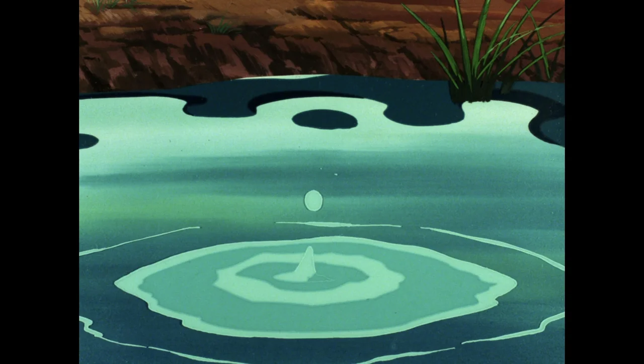 Scooby-Doo on Zombie Island (1998) movie still: closeup — A close-up view of a calm teal pond with a muddy bank at the top. A single water droplet…