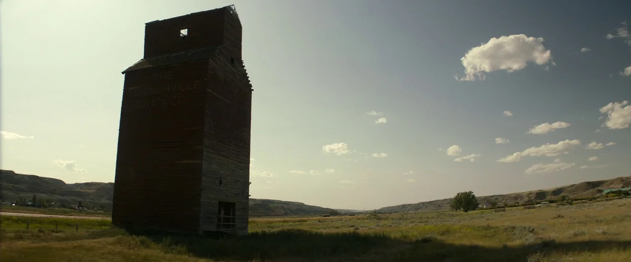 Ghostbusters: Afterlife (2021) movie still: establishing — A tall, weathered wooden grain elevator stands isolated in a vast, grassy rural…