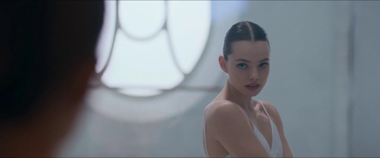 Birds of Paradise (2021) movie still: medium — A light-filled dance studio features a prominent circular window against a pale wall. A young woman…