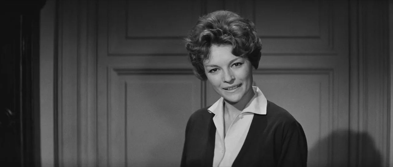 La Dolce Vita (1960) movie still: medium — A woman stands before a paneled wall with classic molding in a domestic interior. She looks directly at…